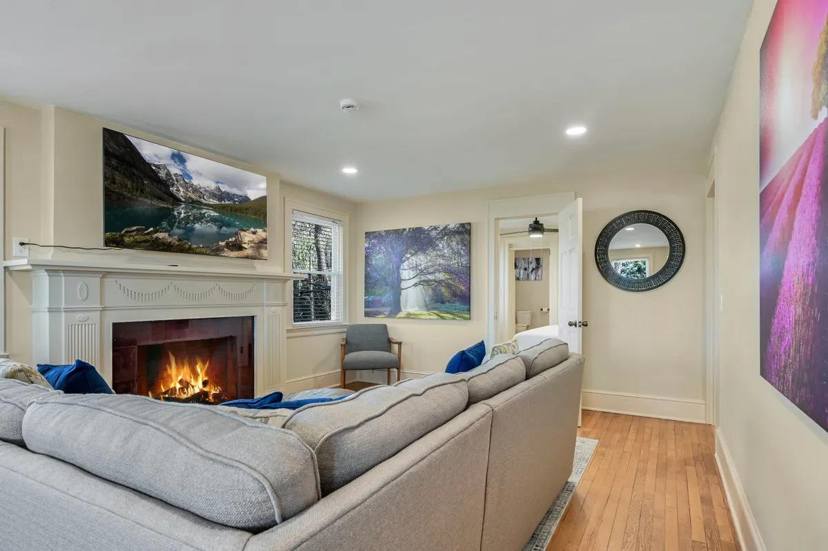A welcoming interior living space with a large sofa and a fireplace, accented by wall art, offering a cozy atmosphere to gather and share stories after a day of exploration.